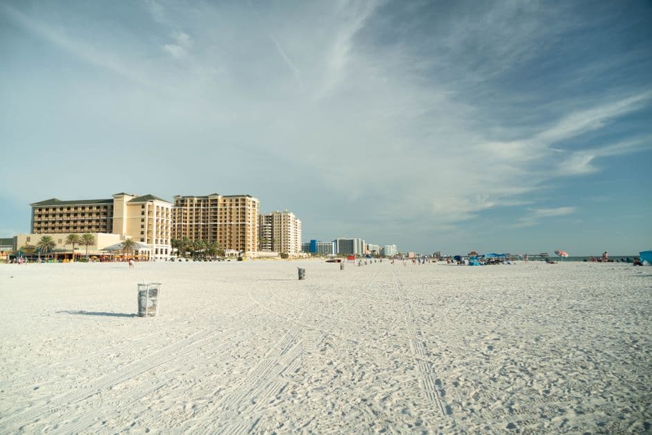 Wide sandy beach with high-rise hotels under a bright sky. Perfect summer getaway.